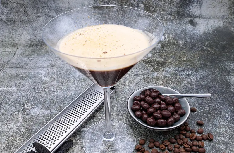 Espresso Martini mit Tonkabohne im Cocktailglas, garniert mit Crema und Kaffeebohnen
