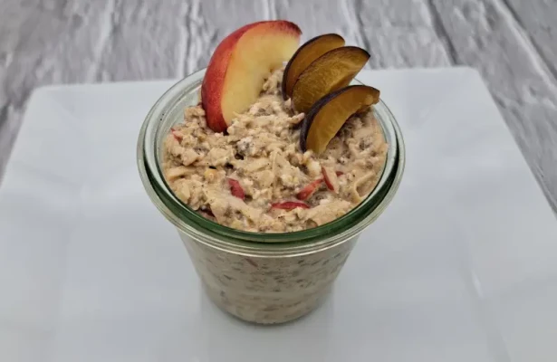 Cremige Overnight Oats im Glas, garniert mit frischen Beeren, gehackten Nüssen und einem Hauch Zimt
