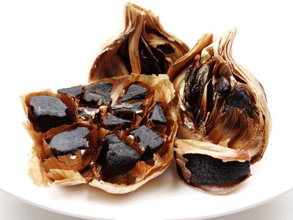 Schale mit fermentierten schwarzen Bio Knoblauchknollen